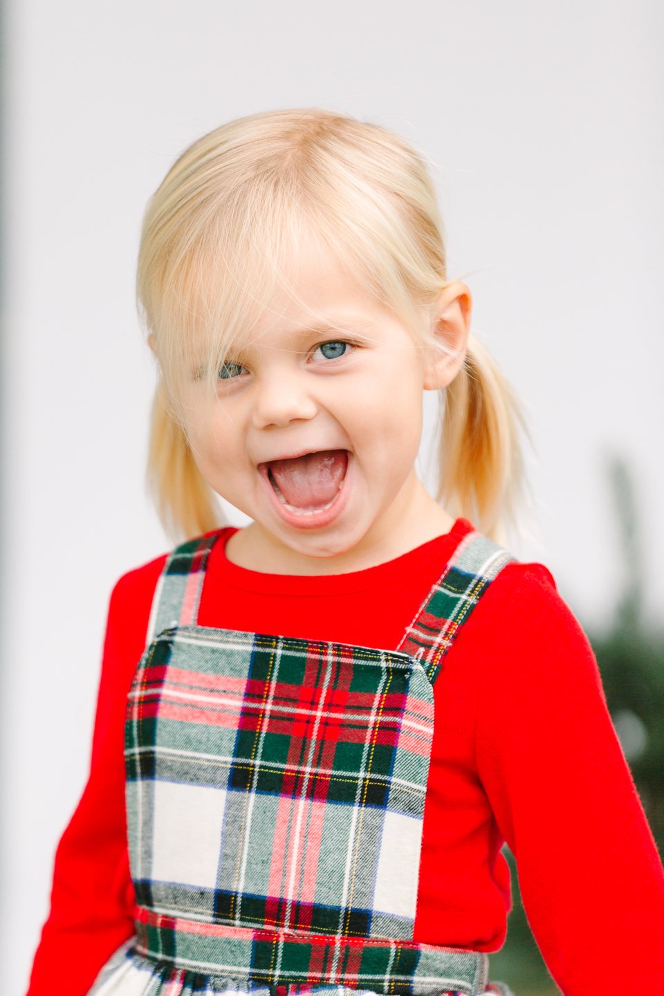 Laughing child in a plaid holiday dress in the studio