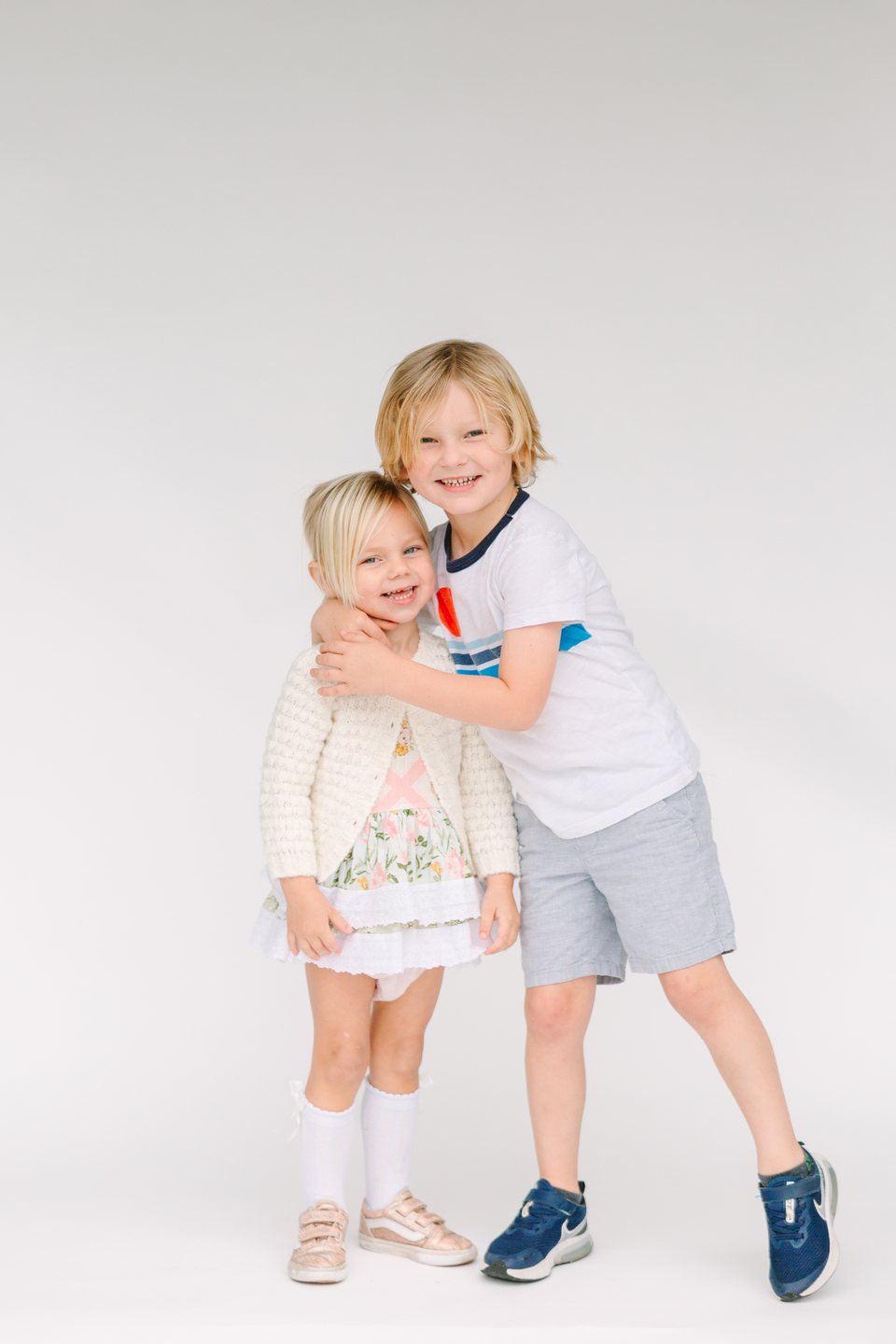 Brother and sister hugging and laughing in the studio