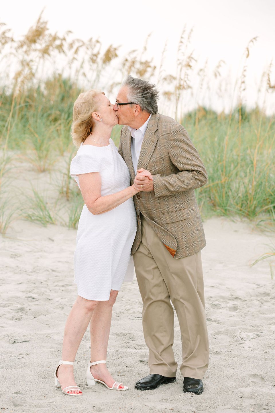 Couple kissing in the dunes at the beach