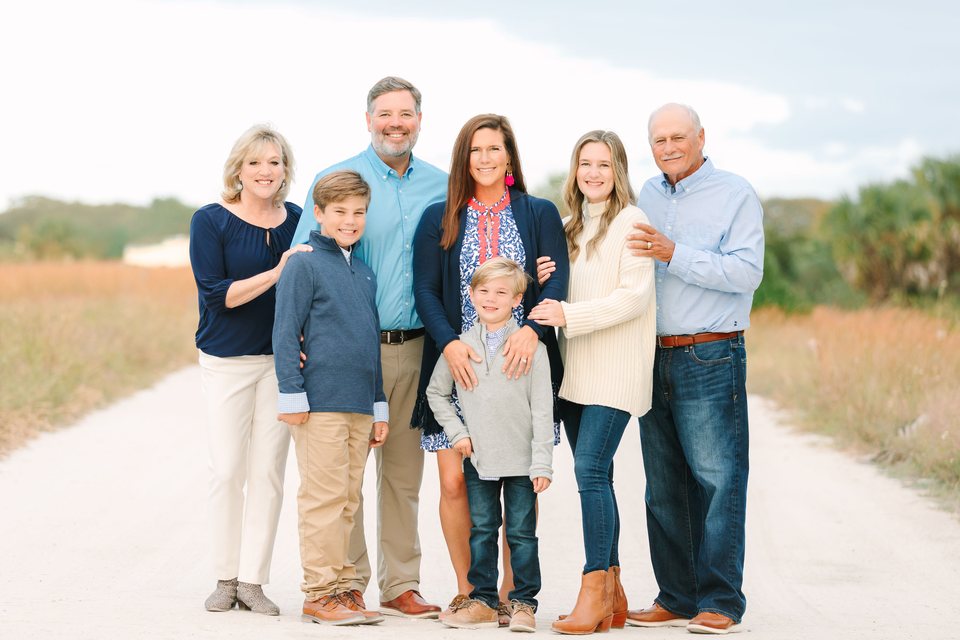 Extended family together on a pale beach path