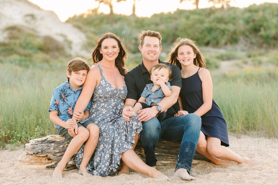 Family of five sitting together in the dunes