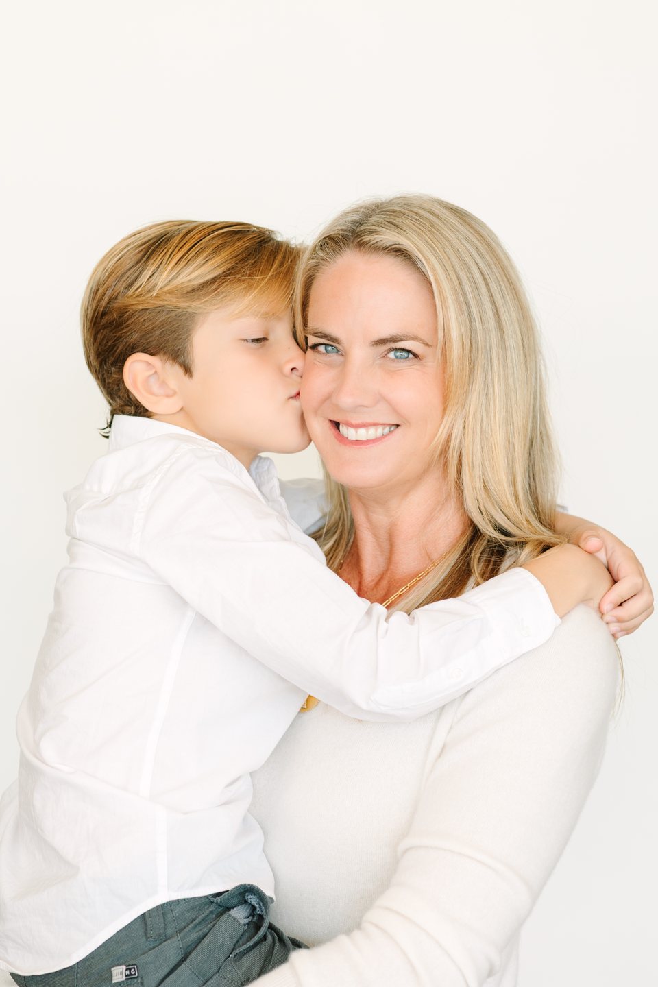 Boy kissing his mother's cheek in the studio