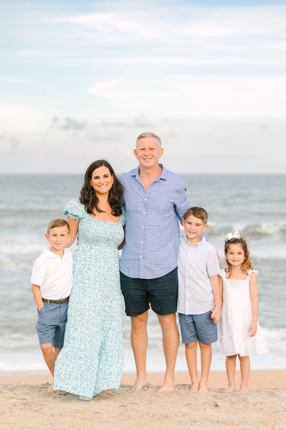 Family of five standing together at the water's edge
